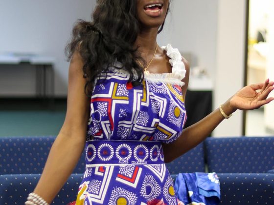 A young woman singing with her arm outstretched during praise.