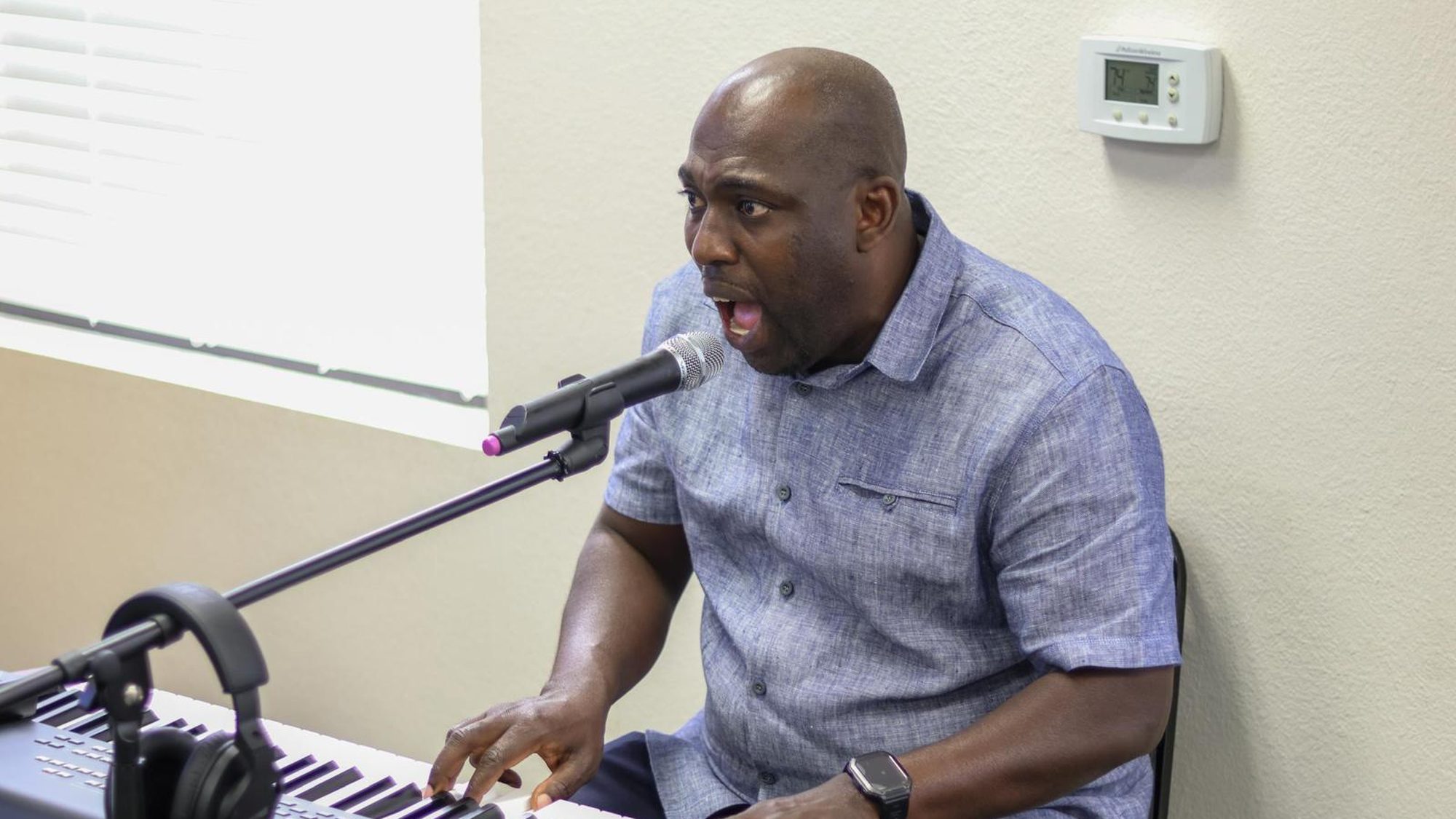 A musician leading worship from the keyboard during a Sunday service.
