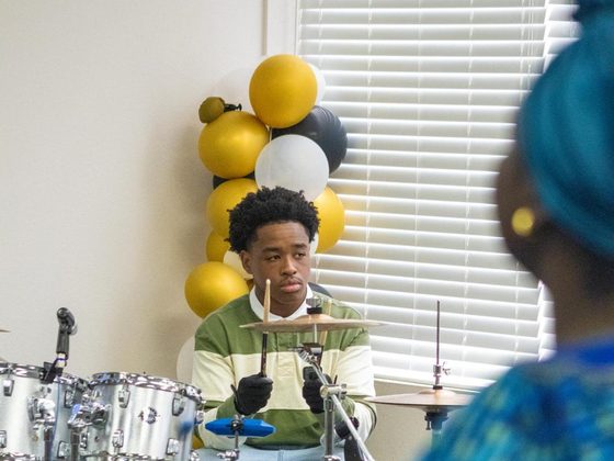 A young drummer playing during a Sunday celebration.